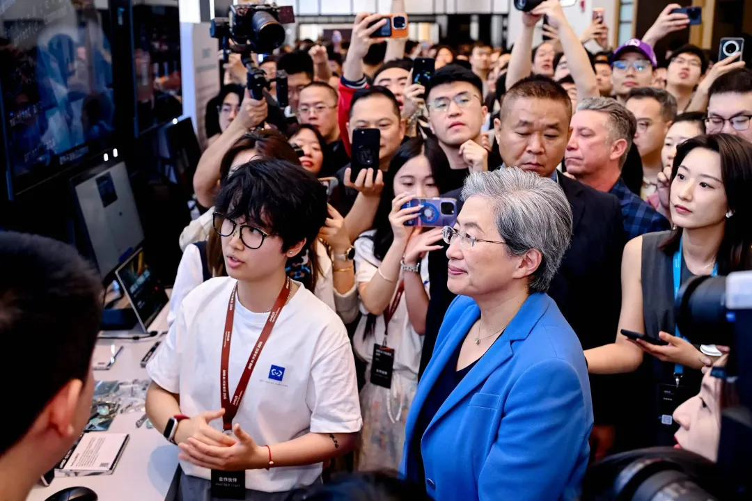 AMD AI 开发者日现场，苏姿丰在 Datawhale 展台前与开发者交流